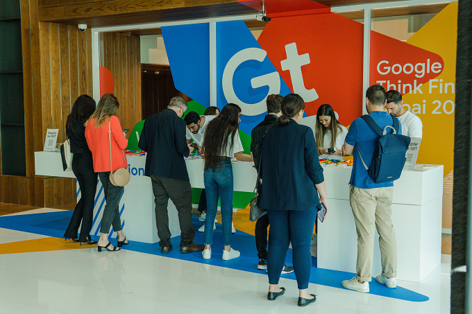 Attendees checking in at the registration desk beneath large-scale 'Gt' branded signage