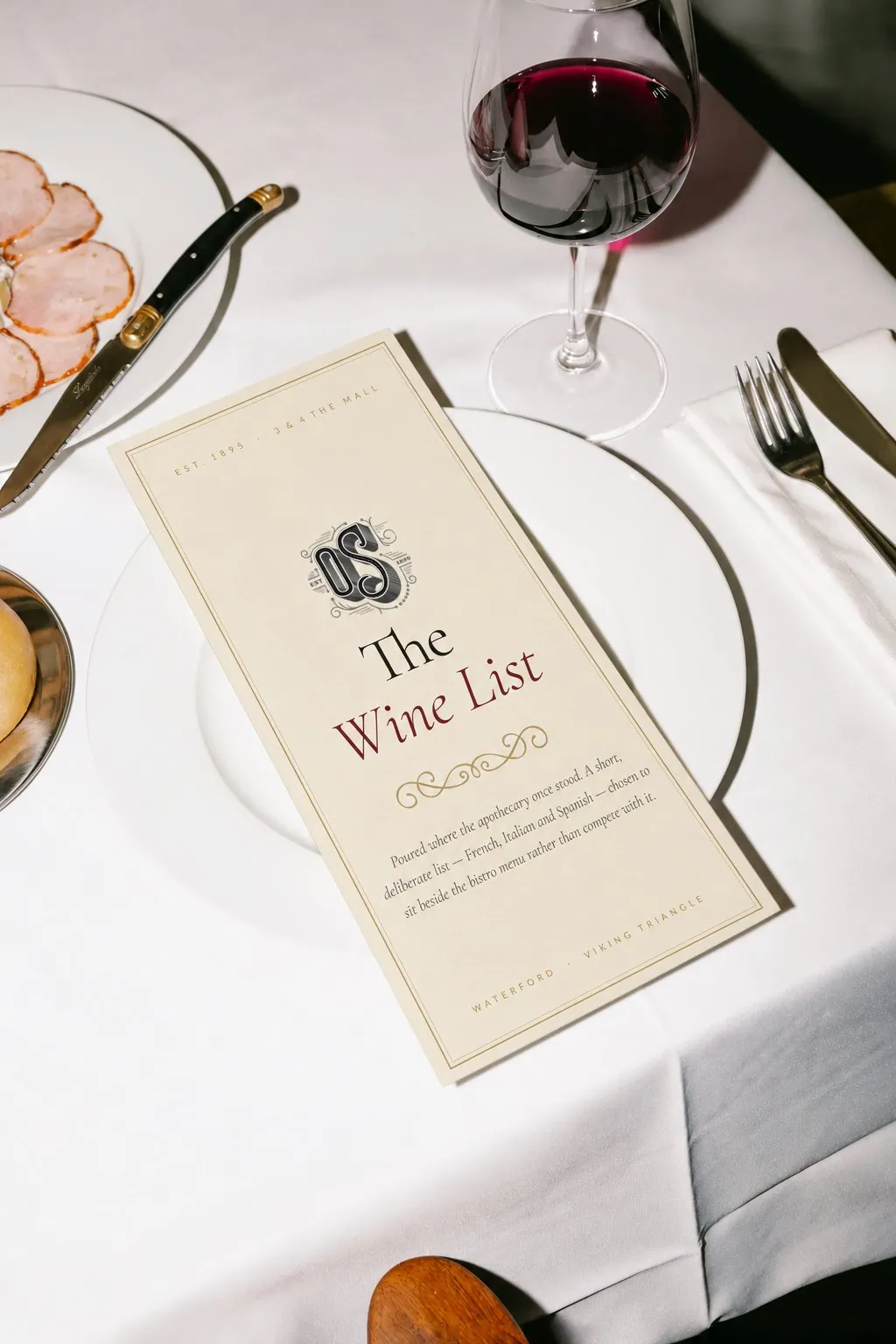 The O'Sullivans wine list cover on a plate, with the OS monogram and the words The Wine List